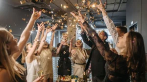 Corporate team celebrating with confetti and champagne during a company event.