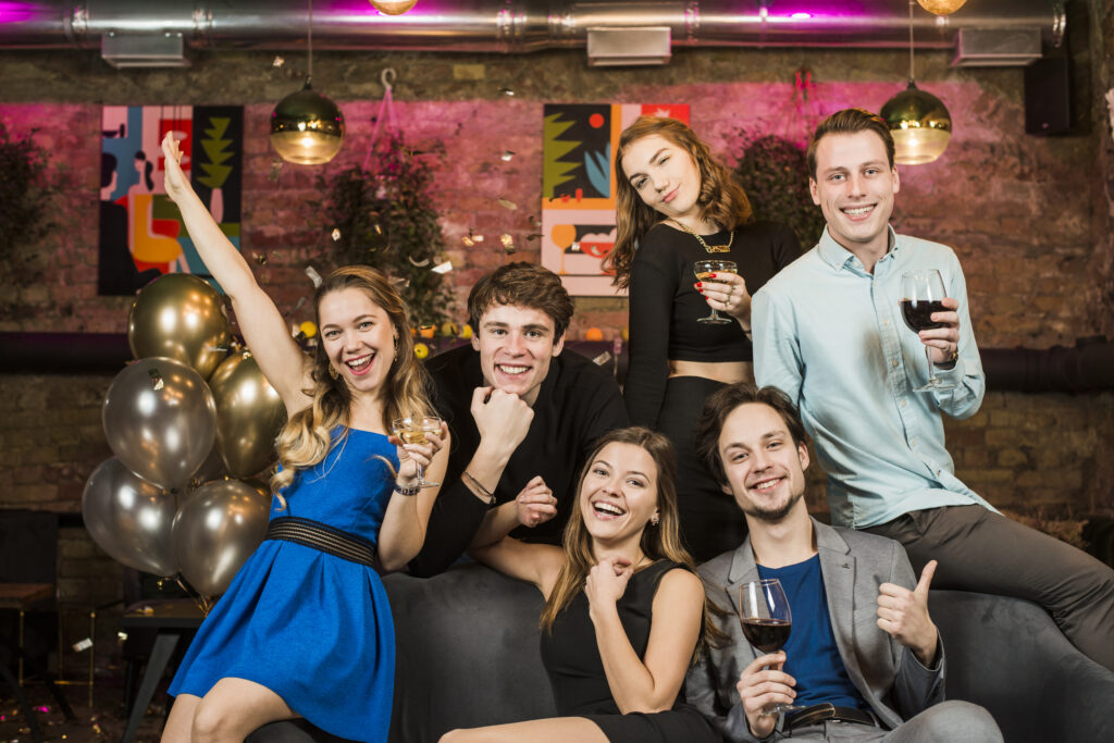 portrait smiling young couples holding wine glasses enjoying a party